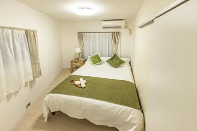 a bedroom with a bed with a stuffed animal on it at SUNRISE STAY Ebisu in Tokyo