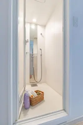 a bathroom with a shower and a basket of towels at SUNRISE STAY Ebisu in Tokyo