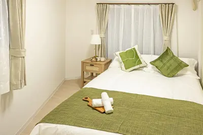 a stuffed dog laying on a bed in a bedroom at SUNRISE STAY Ebisu in Tokyo