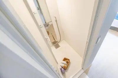 a bathroom with a shower and a toilet paper dispenser at SUNRISE STAY Ebisu in Tokyo