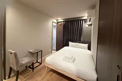 a bedroom with a bed and a chair and a mirror at AHAI \u30db\u30c6\u30eb2 - Tokyo Private VILLA in Tokyo
