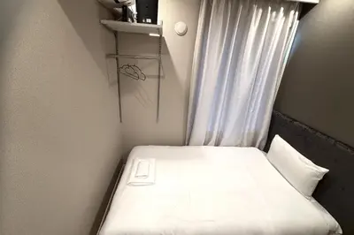 a small bed in a room with a window at AHAI \u30db\u30c6\u30eb2 - Tokyo Private VILLA in Tokyo