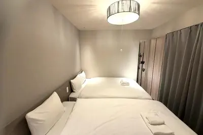 a small room with two beds and a light at AHAI \u30db\u30c6\u30eb2 - Tokyo Private VILLA in Tokyo