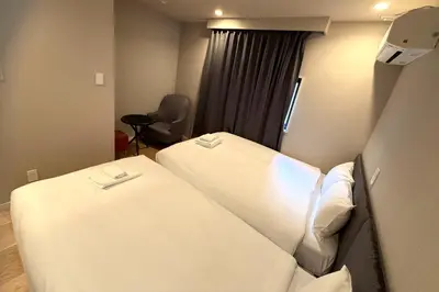 a hotel room with two beds and a chair at AHAI \u30db\u30c6\u30eb2 - Tokyo Private VILLA in Tokyo