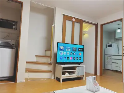 a living room with a flat screen tv sitting on a table at \u65b0\u5927\u4e45\u4fdd\u7f8e\u98df\u8857\u9ad8\u7d1a\u6c11\u6cca in Tokyo