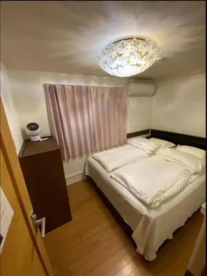 a bedroom with a bed and a chandelier at \u65b0\u5927\u4e45\u4fdd\u7f8e\u98df\u8857\u9ad8\u7d1a\u6c11\u6cca in Tokyo