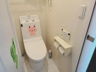 a bathroom with a toilet with a pig sticker on it at \u65b0\u5927\u4e45\u4fdd\u7f8e\u98df\u8857\u9ad8\u7d1a\u6c11\u6cca in Tokyo