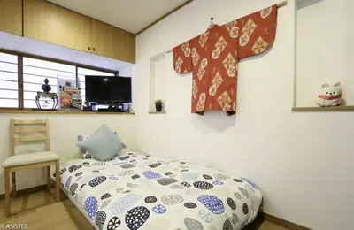 a bedroom with a bed and a teddy bear on the wall at Corpo HARU 101 - Vacation STAY 23522v in Tokyo