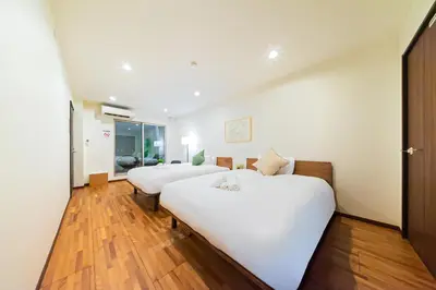 two white beds in a room with wooden floors at STARRY STAY HOUSE SHIBUYA I - Vacation STAY 65376v in Tokyo