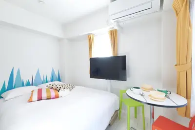 a bedroom with a bed and a table with a tv at Rio Grande Nishi-Shinjuku 5-chome - Vacation STAY 82753v in Tokyo