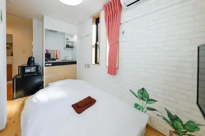 a white bedroom with a white brick wall at Zenith Shinjuku-Hunoki- - Vacation STAY 82828v in Tokyo