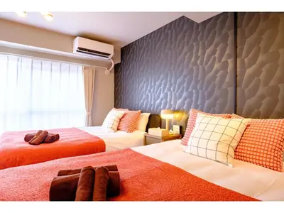a bedroom with two beds and a wall at Living Stay Plum Residence - Vacation STAY 20585 in Tokyo