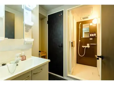 a bathroom with a sink and a shower with a door at Living Stay Plum Residence - Vacation STAY 20585 in Tokyo