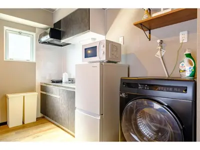 a kitchen with a washing machine and a microwave at Living Stay Plum Residence - Vacation STAY 20586 in Tokyo