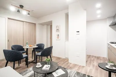 a living room with tables and chairs and a kitchen at ASMACi MAISON\u4e21\u56fd I in Tokyo