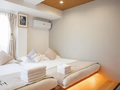 a bedroom with two beds with white sheets at \u685c\u306e\u5ddd73 \u521d\u53f0\u99c55\u5206 2-4\u4eba\u4e285 minute from Hatsudai 2-4 people in Tokyo