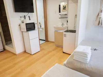a room with a bed and a sink and a microwave at \u685c\u306e\u5ddd73 \u521d\u53f0\u99c55\u5206 2-4\u4eba\u4e285 minute from Hatsudai 2-4 people in Tokyo