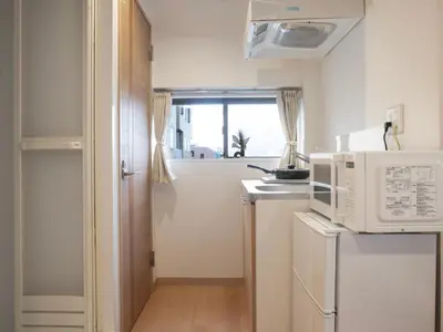 a small kitchen with a microwave and a window at \u685c\u306e\u5ddd74 \u521d\u53f0\u99c55\u5206 2\u4eba\u4e285 minute from Hatsudai 2 people in Tokyo