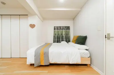 a white bedroom with a bed and a window at Nine Lane Nippori II in Tokyo