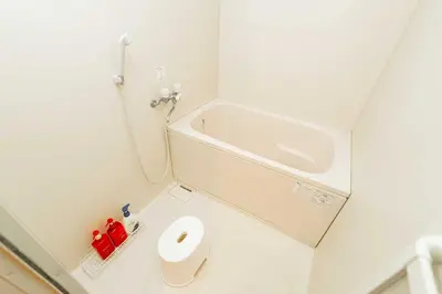 a white bathroom with a tub and a toilet at Nine Lane Nippori II in Tokyo