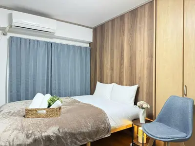 a bedroom with a bed and a blue chair at Shinjuku Area 302 Shinjuku Apartment in Tokyo