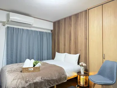 a bedroom with a bed and a blue chair at Shinjuku Area 302 Shinjuku Apartment in Tokyo