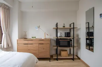 a bedroom with a bed and a dresser with a microwave at CraftFlat Komagome 503, a compact studio at excellent location in Tokyo