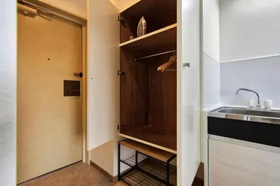a small kitchen with a sink and a closet at CraftFlat Komagome 503, a compact studio at excellent location in Tokyo