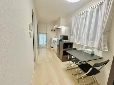 a small apartment with a table and a kitchen at \u5357\u516c\u5712\u30b9\u30ab\u30a4\u30d3\u30e5\u30fc in Tokyo