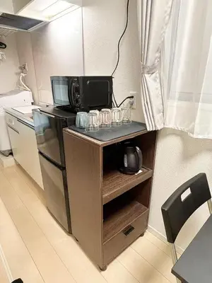 a small kitchen with a counter with a microwave at \u5357\u516c\u5712\u30b9\u30ab\u30a4\u30d3\u30e5\u30fc in Tokyo