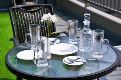 a glass table with plates and glasses and a bottle at Comore Villa 1F in Tokyo