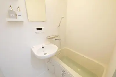 a white bathroom with a sink and a bath tub at Comore Villa 1F in Tokyo