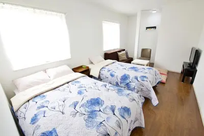 a bedroom with two beds and a window at Comore Villa 1F in Tokyo