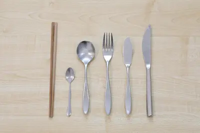a group of silver utensils on a wooden table at Comore Villa 1F in Tokyo