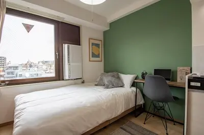 a bedroom with a bed and a desk and a window at CraftFlat Komagome 504, a compact studio at excellent location in Tokyo
