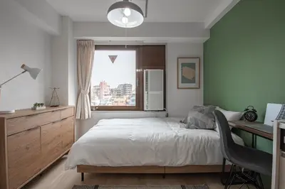 a bedroom with a bed and a desk and a window at CraftFlat Komagome 504, a compact studio at excellent location in Tokyo