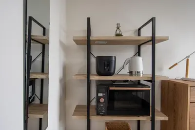a kitchen with a shelf with a microwave on it at CraftFlat Komagome 504, a compact studio at excellent location in Tokyo