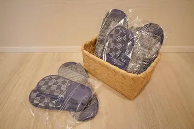 a basket of shoes sitting on a wooden floor at LinksHotel\u4e0a\u91ce in Tokyo