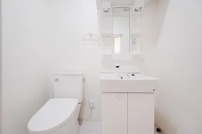 a white bathroom with a toilet and a sink at Vivere in Tokyo