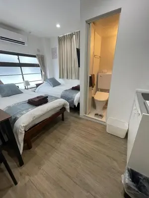 a hotel room with two beds and a bathroom at Yotsuya, 10 seconds from Yotsuya Sanchome Station, in the heart of Shinjuku in Tokyo