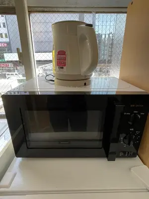 a coffee maker sitting on top of a microwave at Yotsuya, 10 seconds from Yotsuya Sanchome Station, in the heart of Shinjuku in Tokyo