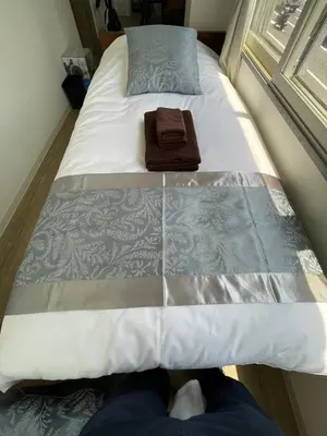 a person laying on a bed in a room at Yotsuya, 10 seconds from Yotsuya Sanchome Station, in the heart of Shinjuku in Tokyo