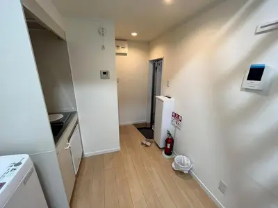 a small kitchen with a refrigerator and a wooden floor at Shinjuku 5 min, Nakano station 1 min walk, 101 in Tokyo