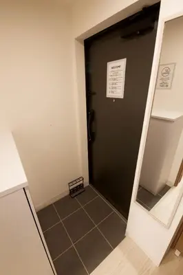 a hallway with a black door and a tile floor at 1 stop to Ikebukuro 3 min walk from station in Tokyo