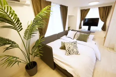 a bedroom with a bed with a plant at 1 stop to Ikebukuro 3 min walk from station in Tokyo