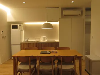 a kitchen with a table and chairs and a refrigerator at PRISM Inn Kagurazaka in Tokyo