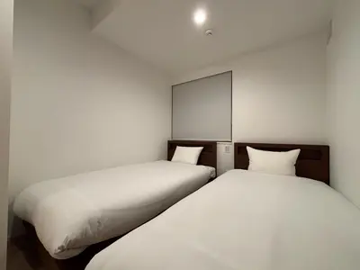 two beds sitting next to each other in a room at PRISM Inn Kagurazaka in Tokyo