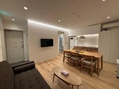 a living room and kitchen with a table and a couch at PRISM Inn Kagurazaka in Tokyo