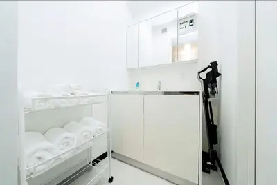 a white kitchen with a sink and a refrigerator at Nine Lane Omori in Tokyo