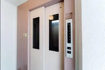 a row of white doors with pictures on the wall at Nine Lane Omori in Tokyo